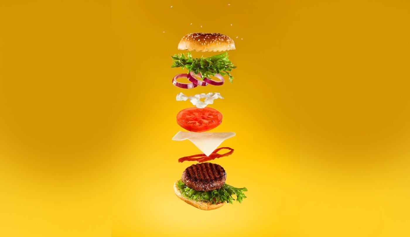 layers of a cheeseburger being added on top of each other