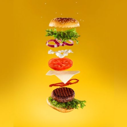 layers of a cheeseburger being added on top of each other
