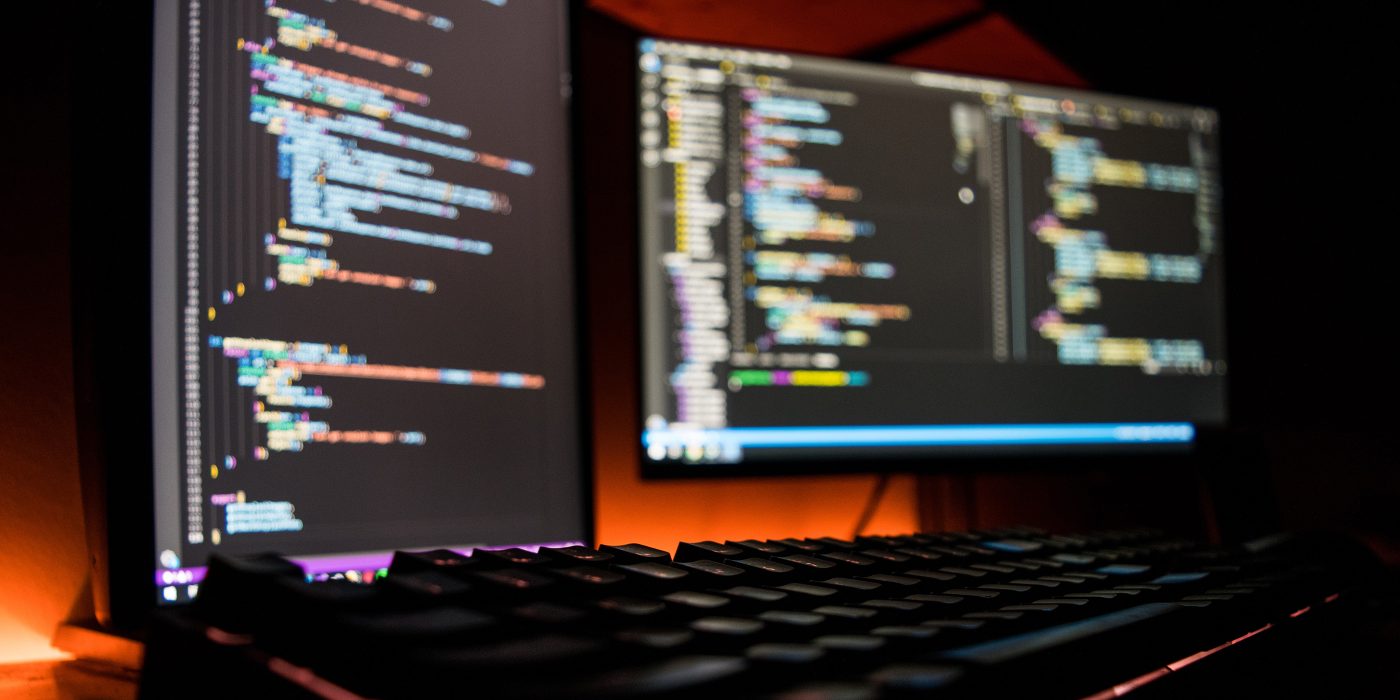 two monitors coding in a dark room