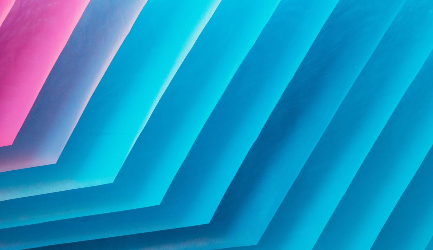 Abstract image with layered colors transitioning from shades of blue and turquoise to pink.