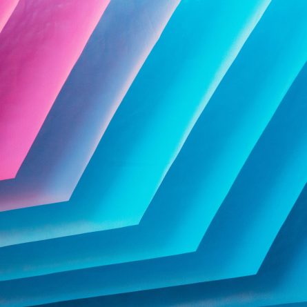 Abstract image with layered colors transitioning from shades of blue and turquoise to pink.