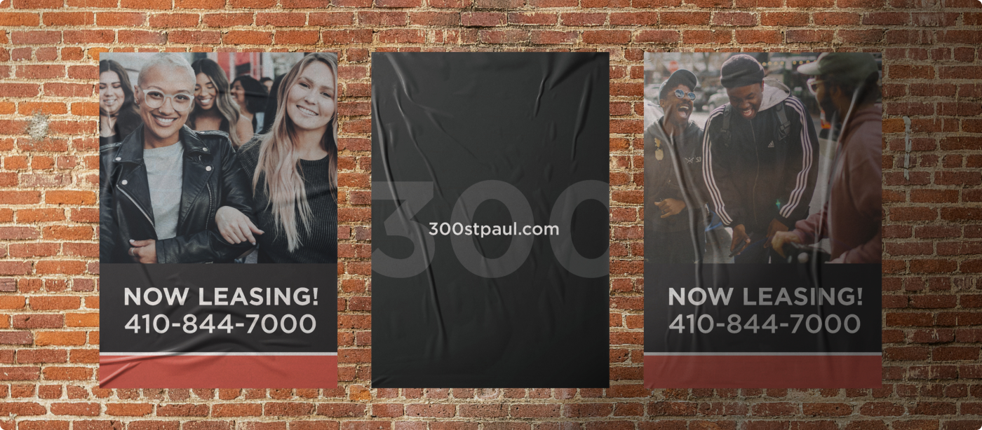 Branding for the 300 Saint Paul property shown on three posters attached to a brick wall.
