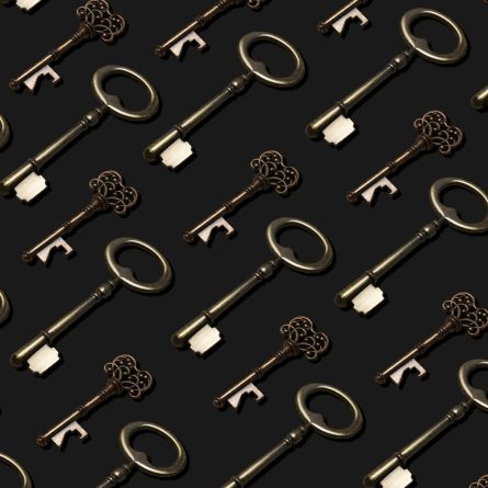 Seamless pattern of vintage brass and bronze skeleton keys on a charcoal background, symbolizing access and hidden knowledge.