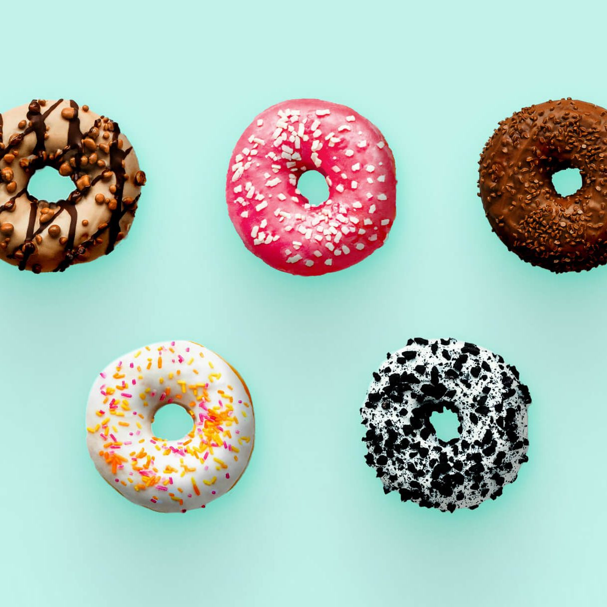 Five uniquely decorated donuts arranged on a pastel background, symbolizing the variety of CMS options available for healthcare websites.