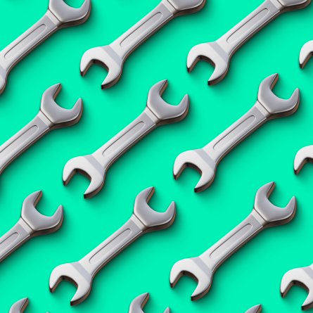 Pattern of silver wrenches arranged diagonally on a bright mint green background, symbolizing website maintenance and reliability.