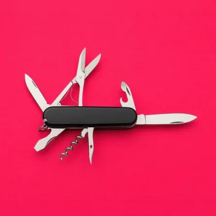 Multi-tool pocket knife with several tools extended on a bright pink background, representing AI readiness, versatility, and marketing preparedness.