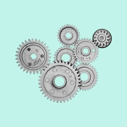 Interlocking gears arranged on a light teal background, illustrating automated workflows, AI agents, and connected marketing processes.