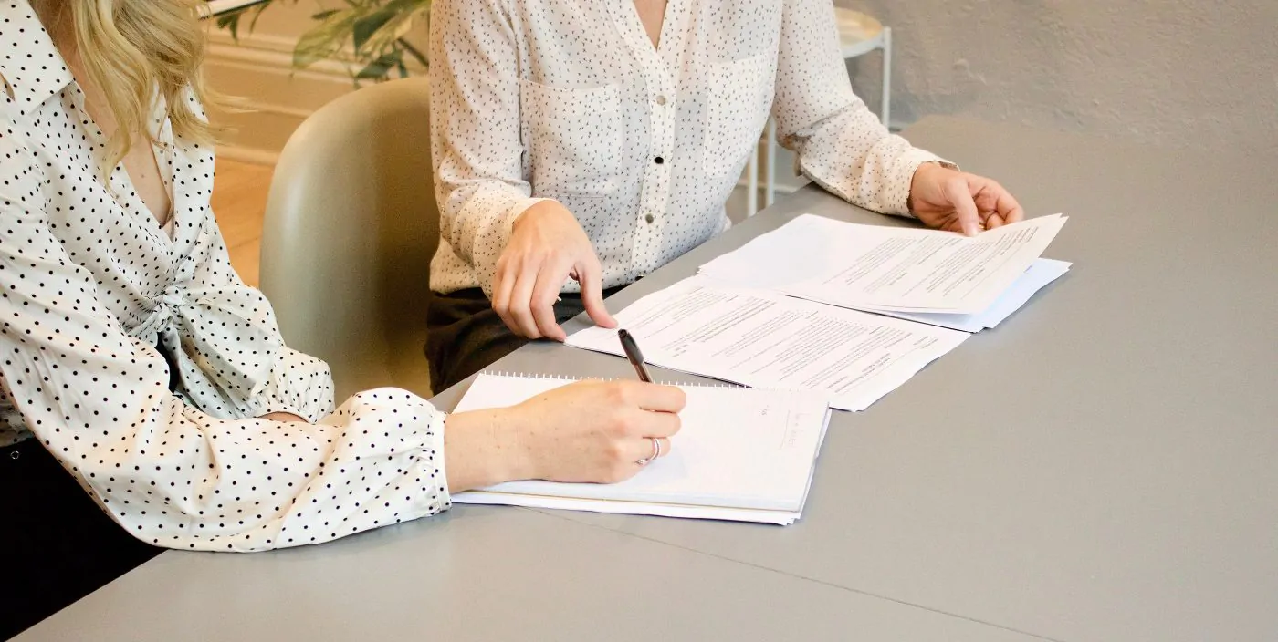 two business women reviewing paperwork together