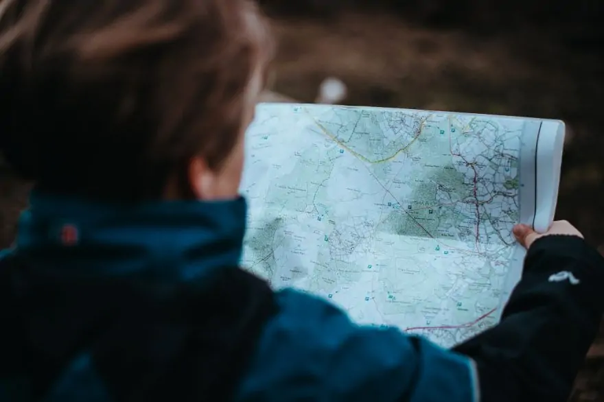 the back of a young woman's head looking over a map