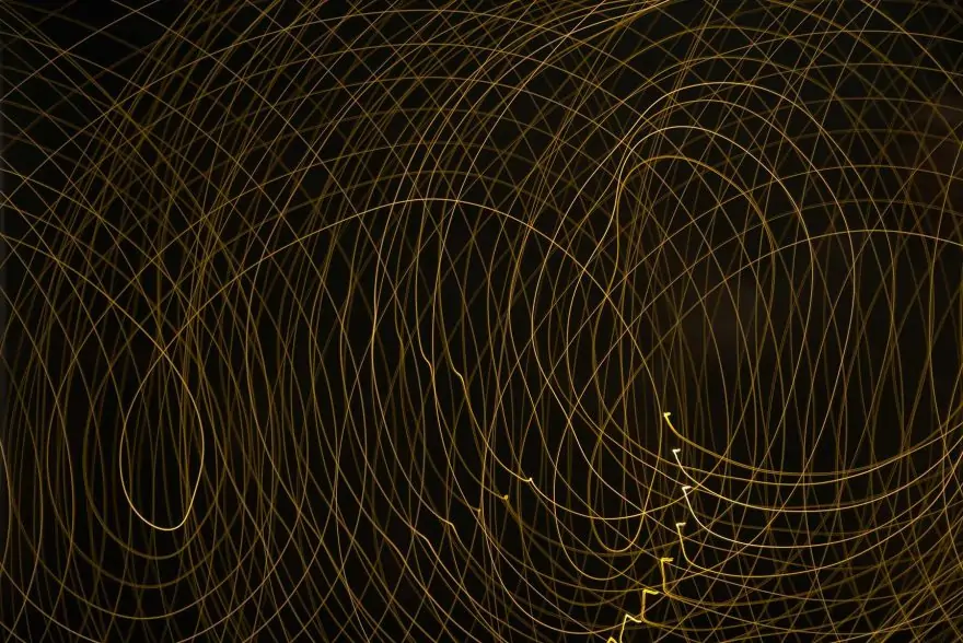golden lines wrapping around each other and spreading out on a black background