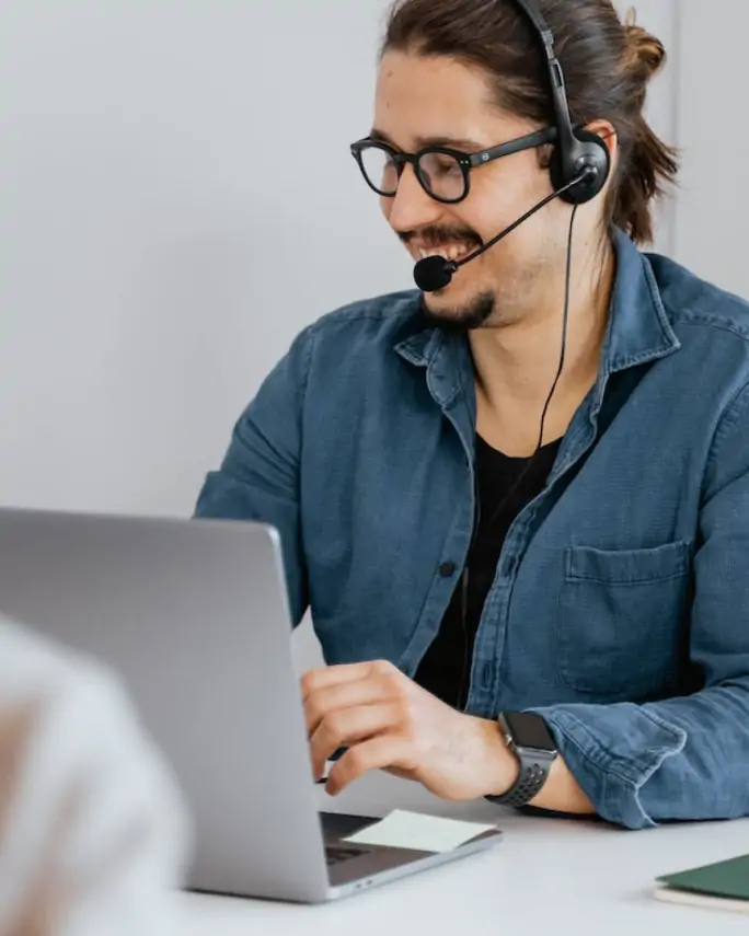 a man working on his laptop wearing a headset