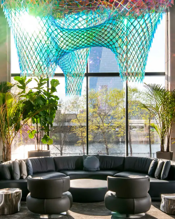 the Riverwalk lobby with colorful netting over leather chairs looking out the window onto the river