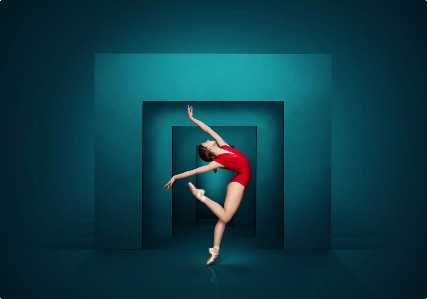 Ballet dancer posing in an arch position against a geometric background.
