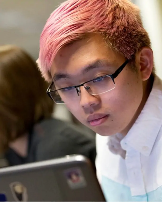 Chinese International student using a laptop in class