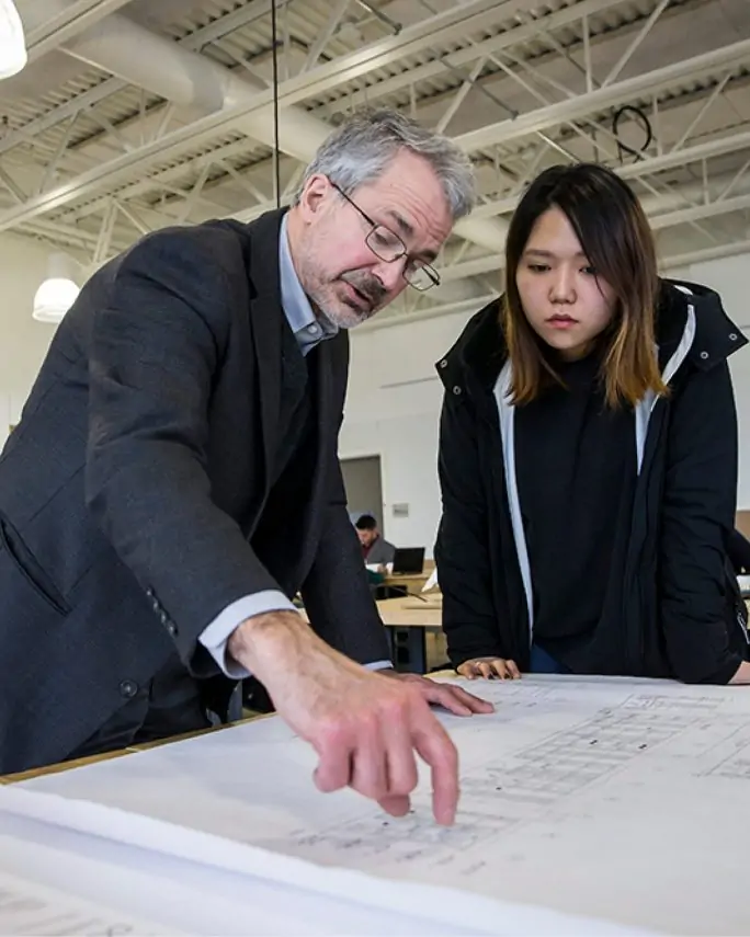 Temple teacher seen with a Chinese international student reviewing a large diagram on the table
