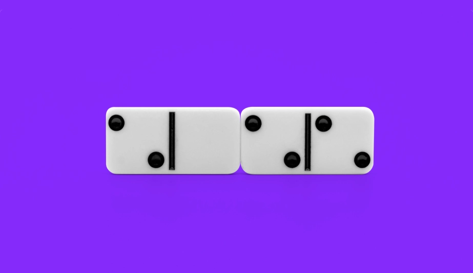 Two domino tiles stacked next to each other on a purple background