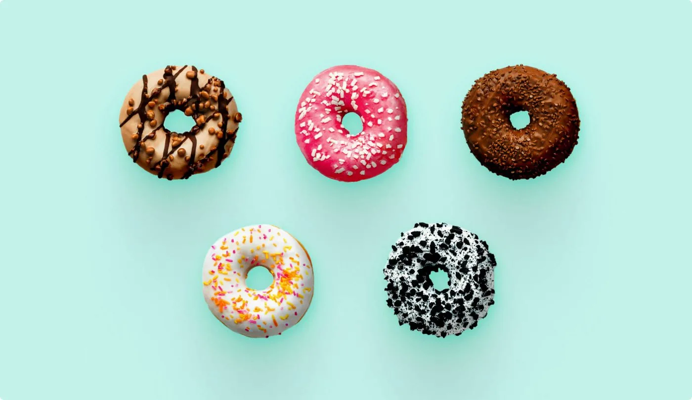 Five uniquely decorated donuts arranged on a pastel background, symbolizing the variety of CMS options available for healthcare websites.