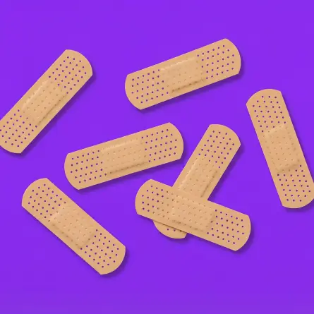 Adhesive bandages scattered on a purple background, representing healthcare and patient care concepts.